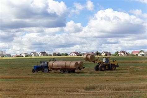 A Tractor Loading Round Hay Bales On To A Trailer Stock Photo Image