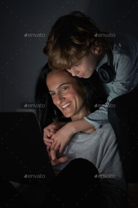 Smiling Mother And Son Watching Movie On Laptop Together While H Stock