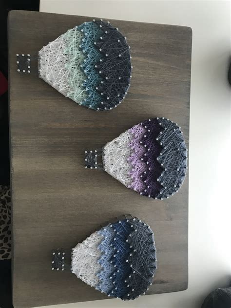 Three Knitted Hats Sitting On Top Of A Wooden Table