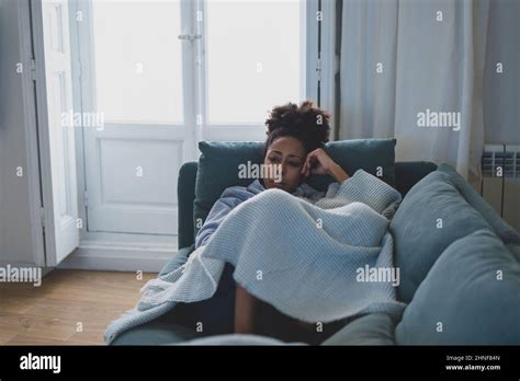 Einsame junge afro latina junge Frau auf dem Sofa Gefühl von Schmerz