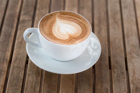 A Cup Of Hot Coffee With Milk Foam Heart Shape On A Rustic Table Stock