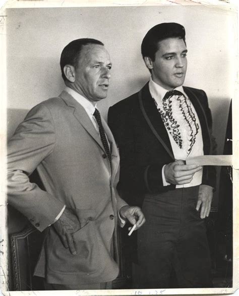 Two Men In Suits Standing Next To Each Other