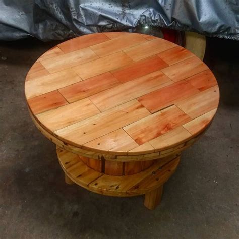 A Round Wooden Table Sitting On Top Of A Hard Wood Floor