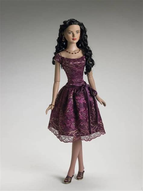 A Doll Dressed In A Purple Dress And High Heeled Shoes Is Standing On A