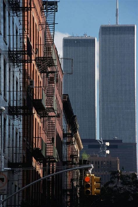 Two Tall Buildings With Balconies In The Background And A Traffic Light