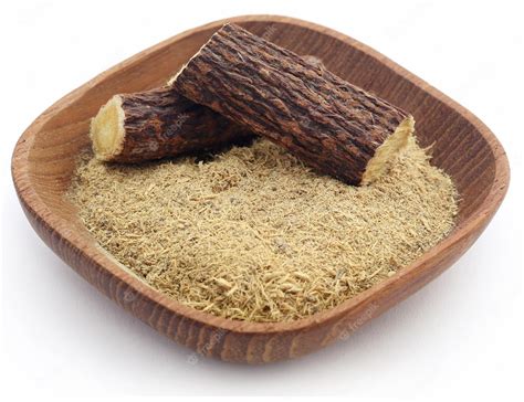 Premium Photo | Liquorice with powder in a bowl over white