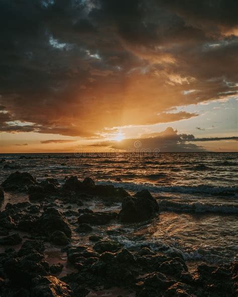 Stunning Sunset Over A Rocky Beach Shoreline With The Glistening Ocean