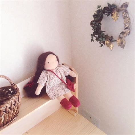 A Doll Is Sitting On A Shelf Next To A Basket And A Wreath In The Corner