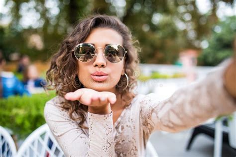 Attractive Young Latin Woman In Sunglasses With Curly Hair Takes A