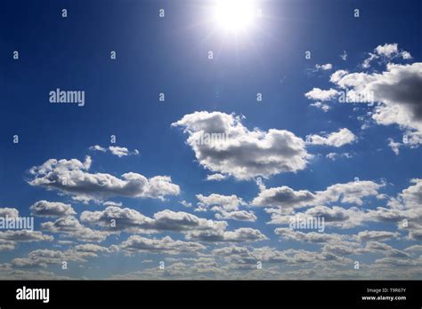 Shining sun and blue sky covered with white cumulus clouds. Summer ...