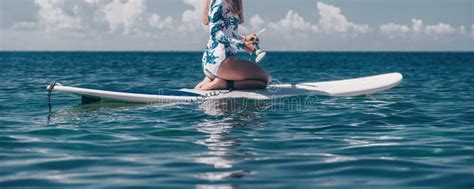 Healthy Happy Fit Woman In Bikini Relaxing On A Sup Surfboard Floating On The Clear Turquoise