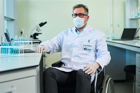 Mature Confident Researcher Sitting In Wheelchair By His Workplace