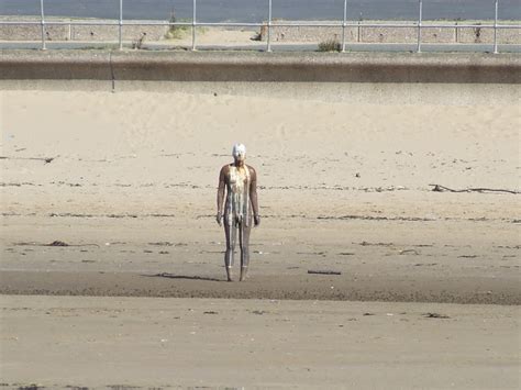 A Man Standing On Top Of A Sandy Beach