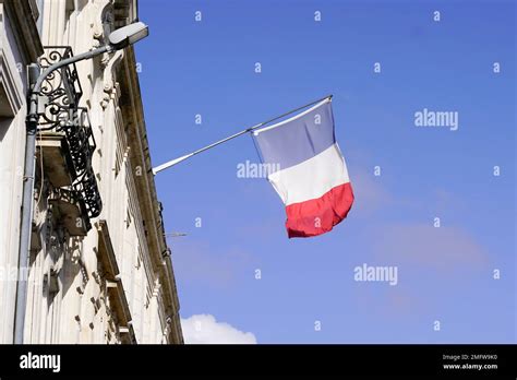 French Tricolor Flag Waving In Front Facade Of Town Hall In City Of