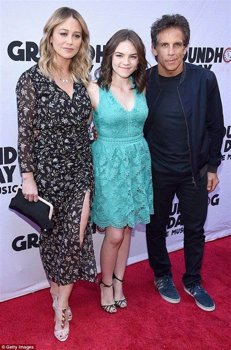 two women and a man standing on a red carpet at the groundhog music awards