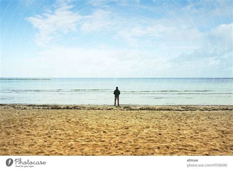 Ein Mann Allein Am Sandstrand Auf Das Stille Meer Blickend Urlaub