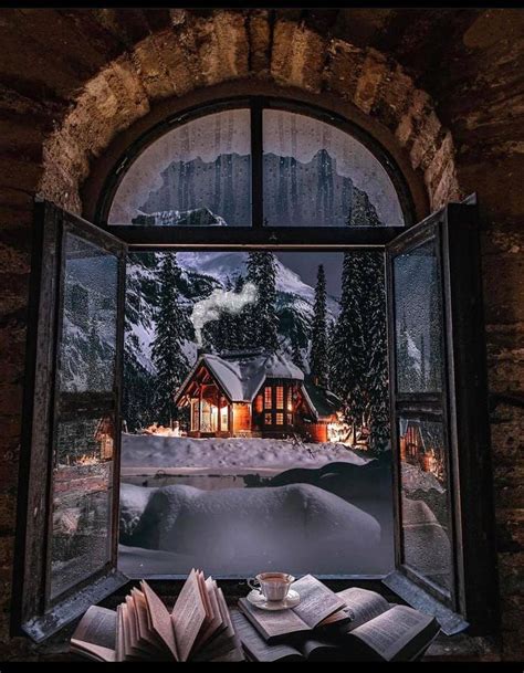 An Open Book Sitting On Top Of A Window Sill Next To Snow Covered Mountains