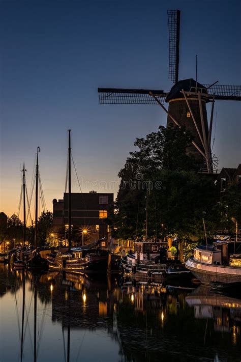 Typcical Dutch Windmill And Boats In The Old Harbor Of Gouda Holland