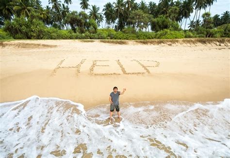 Premium Photo Man Stuck On Uninhabited Island Inscription Help On Sand