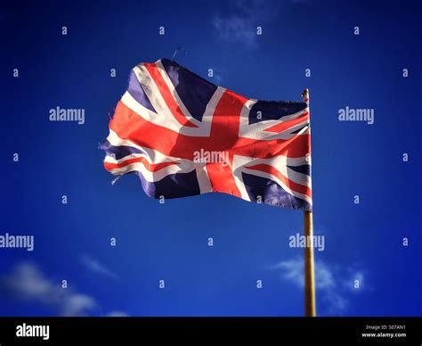 Union Jack Flag Flying Against A Blue Sky Stock Photo Alamy