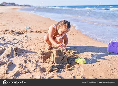 Adorable Niño Rubio Con Bikini Construyendo Castillo Arena Usando Cubo Foto de stock