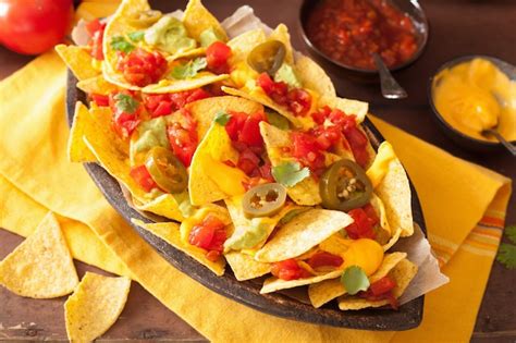 Premium Photo | Nachos loaded with salsa, guacamole, cheese and jalapeno