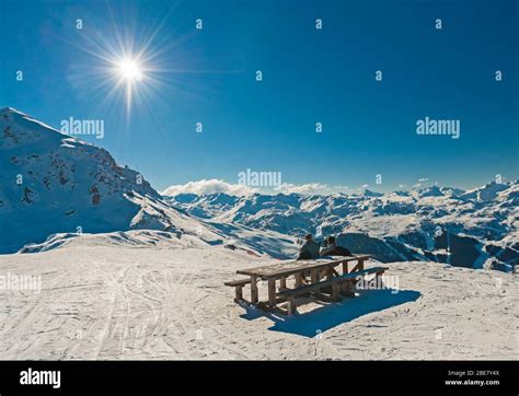 Vista panorámica sobre la cordillera alpina con dos esquiadores