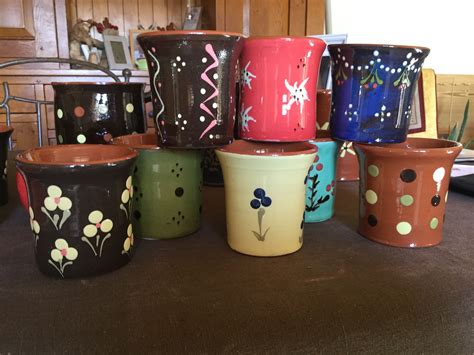 Many Different Colored Flower Pots Sitting On A Counter Top With Polka