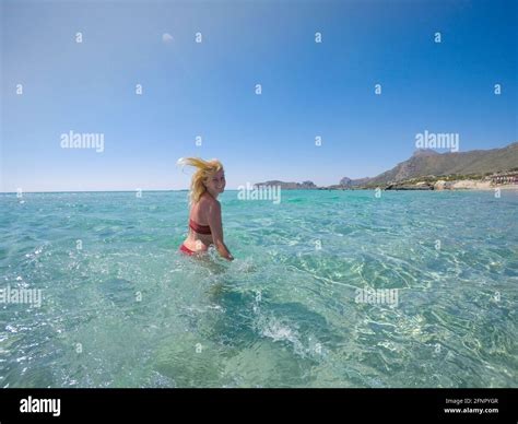 Free Happy Woman In A Bikini Jumping In Shallow Turquoise Water By The