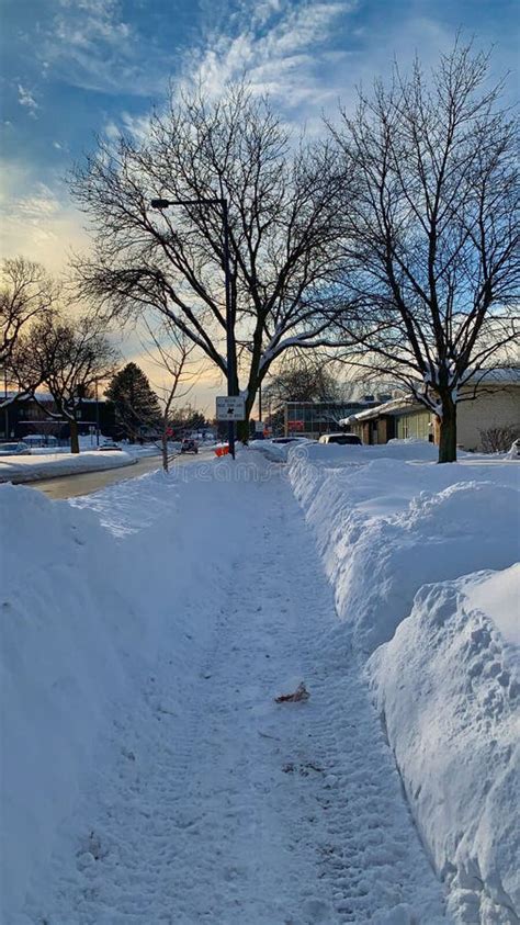 Vertical View A Snowy Sidewalk On A Sunny Day In Winter Stock Photo