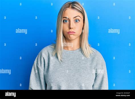 Beautiful Blonde Woman Wearing Casual Clothes Puffing Cheeks With Funny Face Mouth Inflated