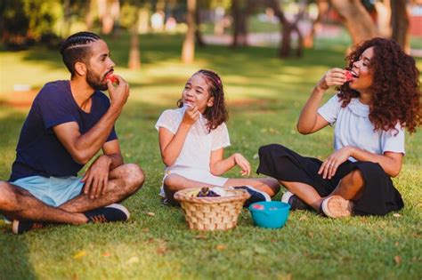 Família feliz fazendo piquenique no parque Foto Premium