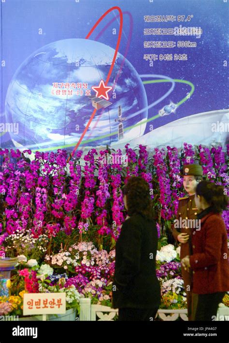 Visitors look at an image of the satellite-carrying rocket ...