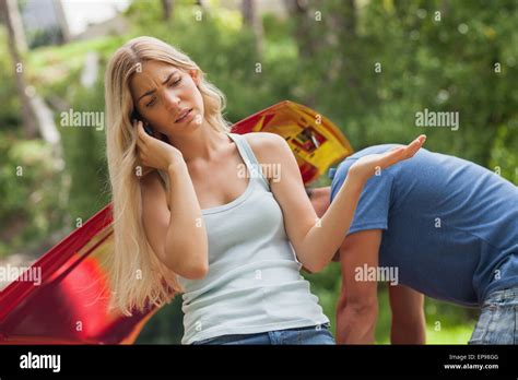 Blonde Woman Calling For Assistance After Breaking Down Stock Photo Alamy