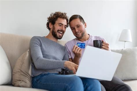 Alegre joven pareja gay sonriendo alegremente mientras compra en línea