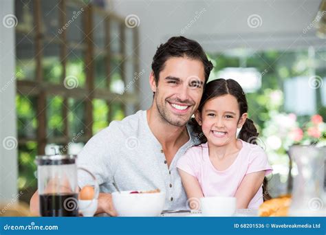 Retrato Del Padre Y De La Hija Sonrientes En La Tabla Foto De Archivo