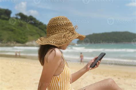 jeune belle femme en bikini écoutant de la musique et utilisant un