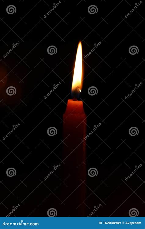 Light Candle Burning Brightly In The Black Background Stock Image