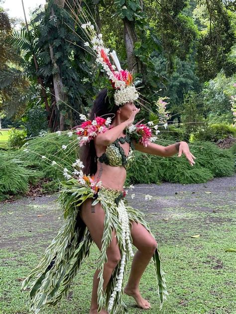 A Woman In A Hula Skirt With Flowers On Her Head And Grass Around Her Waist