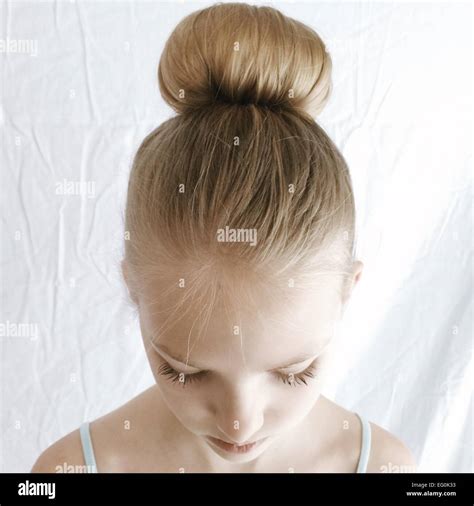 Portrait of a girl with a hair bun looking down Stock Photo - Alamy