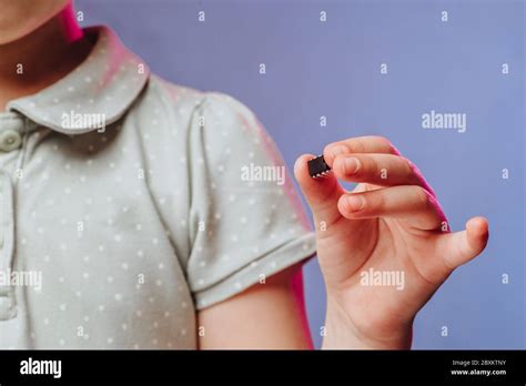girl holds   hand  examines  small black chip chipization