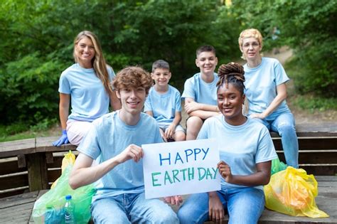 Premium Photo Happy Volunteers Holding Placard With Happy Earth Day