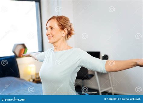 Beaming Mature Woman With Tied Hair Having Workout Morning Session