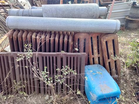 Stack of old radiators sitting outside — Heating Help: The Wall