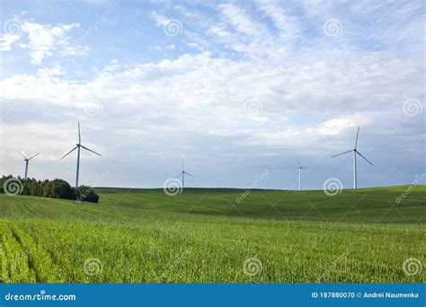 Wind Turbine On The Green Grass Over The Blue Clouded Sky Protection Of Nature Wind Turbine