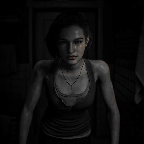 A Woman Standing In A Dark Room Wearing A Tank Top