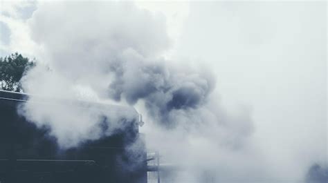 Premium Photo A Steam Engine Blowing Smoke Into The Air