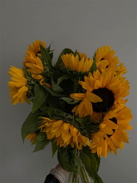 A Vase Filled With Yellow Sunflowers On Top Of A Table