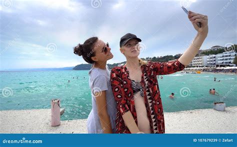 Funny Female Friends On Vacation Taking Selfies On The Beach With A