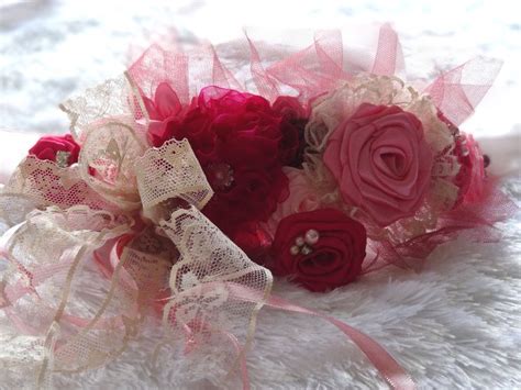 A Bridal Bouquet With Red And Pink Flowers On A White Furnishing Area